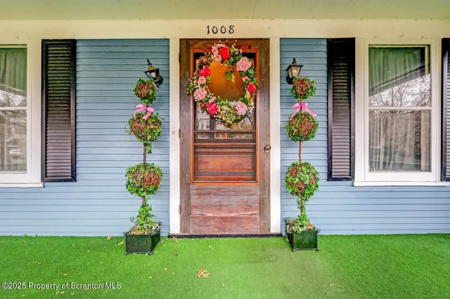 a front view of a house with a yard and potted plant