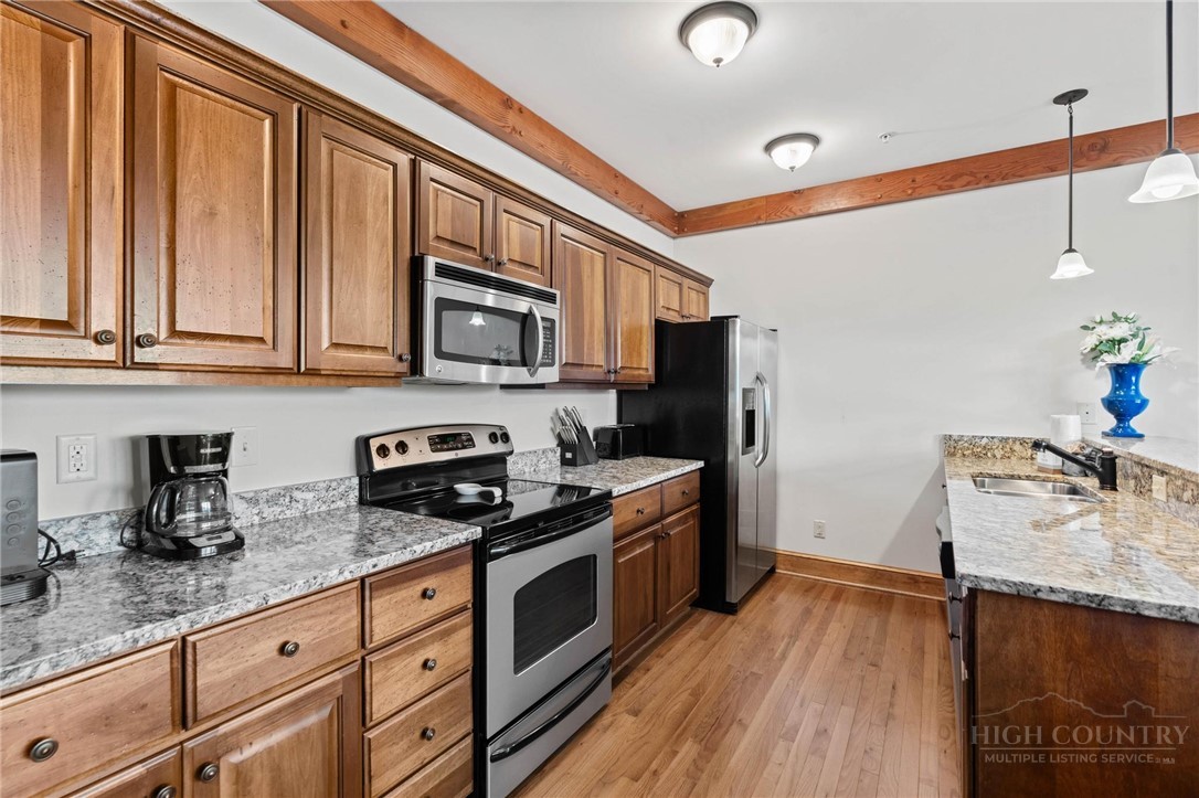 142 Evening View Lane, Unit CA3 Boone, NC 28607 - Photo 8 of 41 a kitchen with stainless steel appliances granite countertop a stove a sink dishwasher and a microwave oven with wooden floor