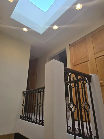 a view of a brick house with wooden fence and floor to ceiling window