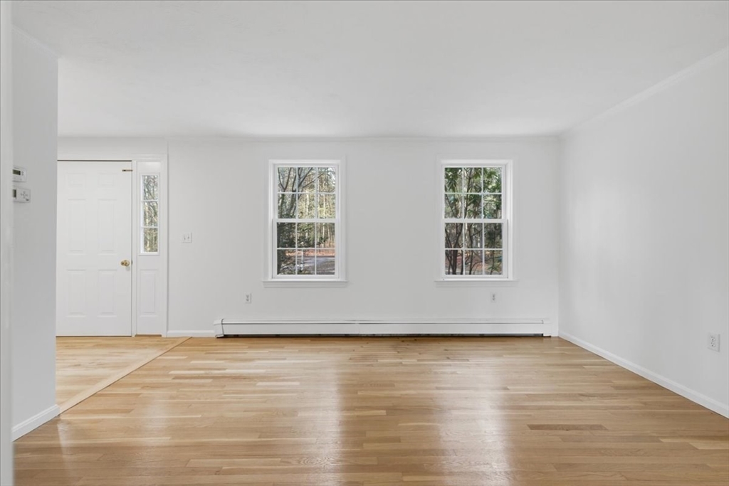 66 Box Pond Drive Bellingham, MA 02019 - Photo 18 of 41 a view of an empty room with wooden floor and a window