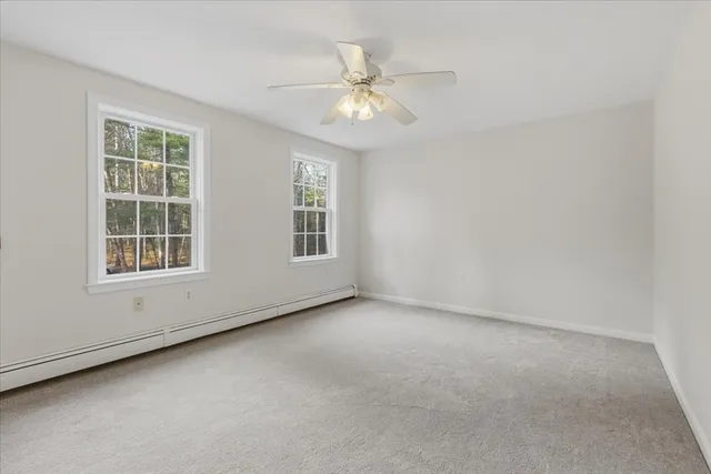 an empty room with windows and chandelier fan