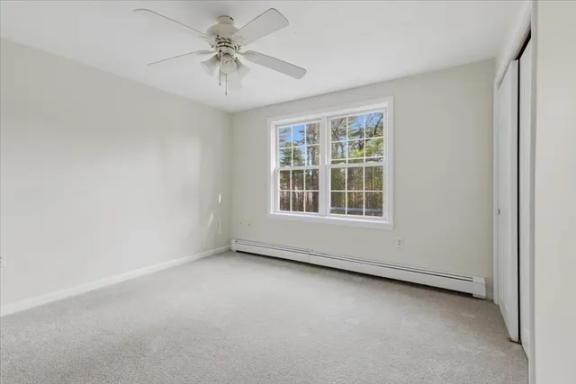 an empty room with windows and fan