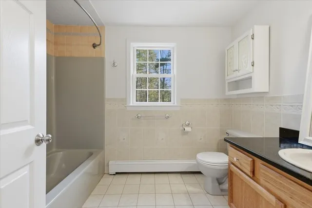 a bathroom with a granite countertop sink a toilet and bathtub