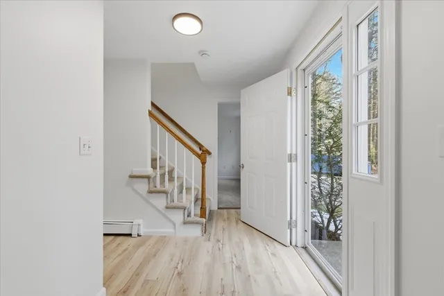 a view of hallway with stairs and wooden floor