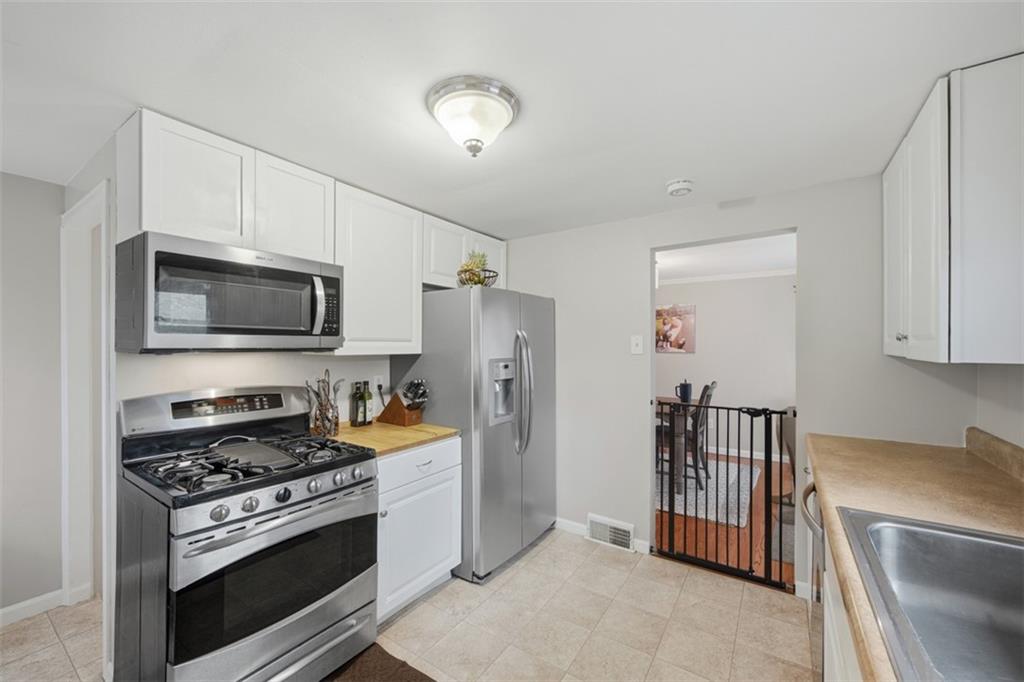 2725 Locust Drive Pittsburgh, PA 15241 - Photo 11 of 40 a kitchen with stainless steel appliances granite countertop a stove a refrigerator and a microwave