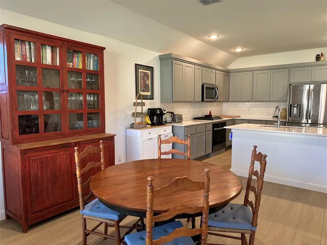 a kitchen with a table chairs refrigerator and cabinets