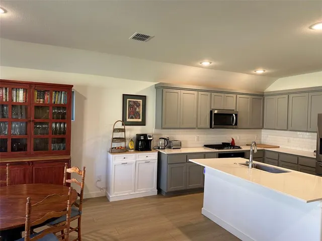 a kitchen with kitchen island a sink stainless steel appliances and cabinets