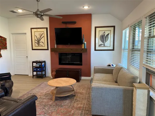 a living room with furniture a flat screen tv and a fireplace