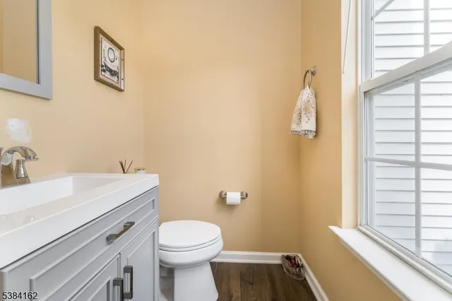 a bathroom with a sink a toilet and a window