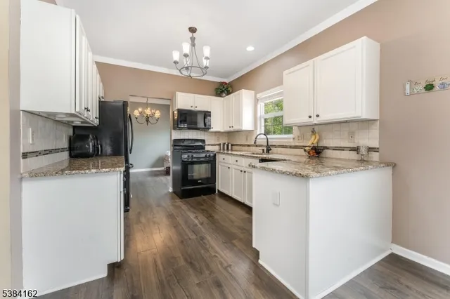 a kitchen with kitchen island granite countertop stainless steel appliances cabinets a sink and a counter top space