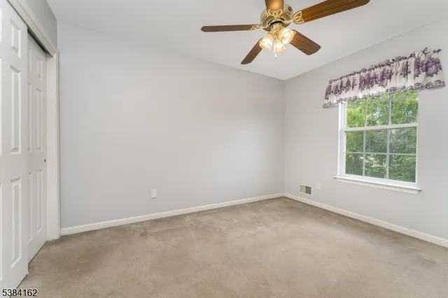 en empty room with windows and ceiling fan