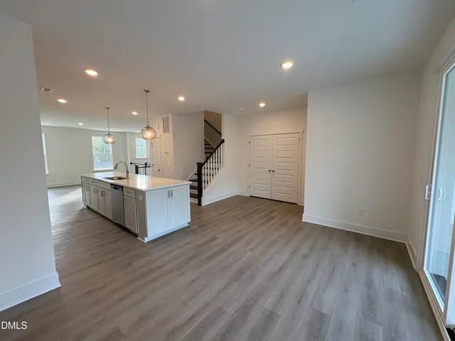 a view of kitchen with kitchen island wooden floors and stainless steel appliances