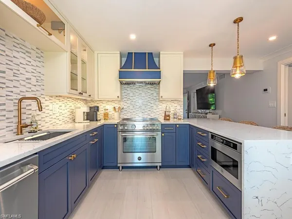 a kitchen with stainless steel appliances granite countertop a stove a sink and a microwave