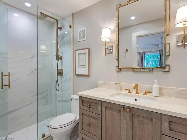 a bathroom with a sink a toilet and shower