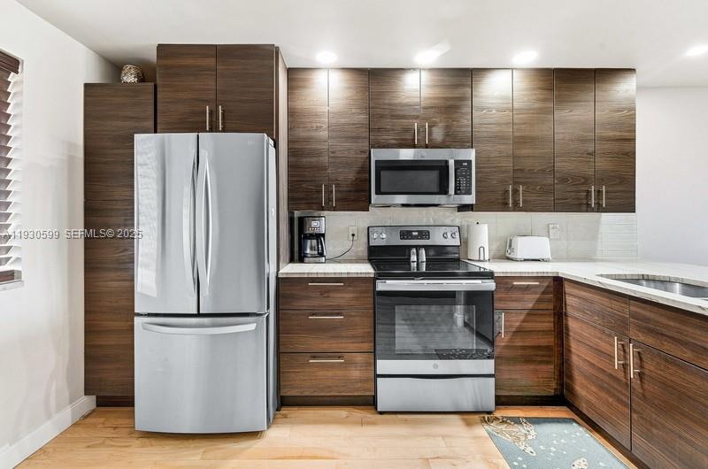 353 Highway 1, Unit C404 Jupiter, FL 33477 - Photo 11 of 30 a kitchen with a refrigerator sink and microwave