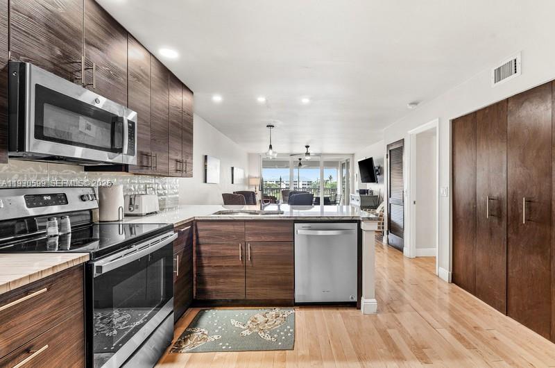 353 Highway 1, Unit C404 Jupiter, FL 33477 - Photo 9 of 30 a kitchen with stainless steel appliances granite countertop a stove sink and cabinets