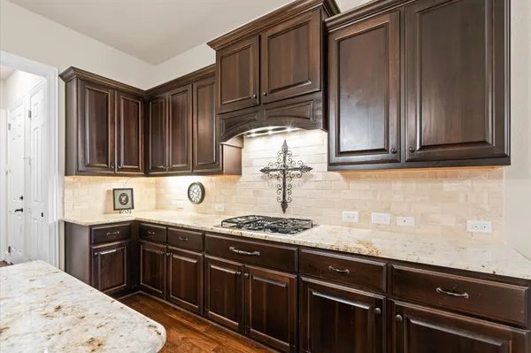 a kitchen with granite countertop a sink stove and cabinets