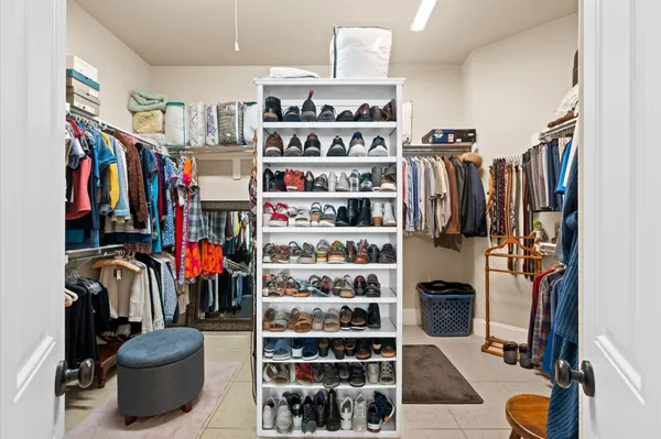 a view of walk in closet with clothes and shoes