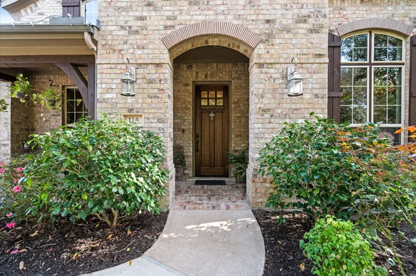 a stone house with potted plants in front of door