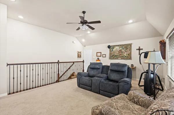 a living room with furniture and a ceiling fan