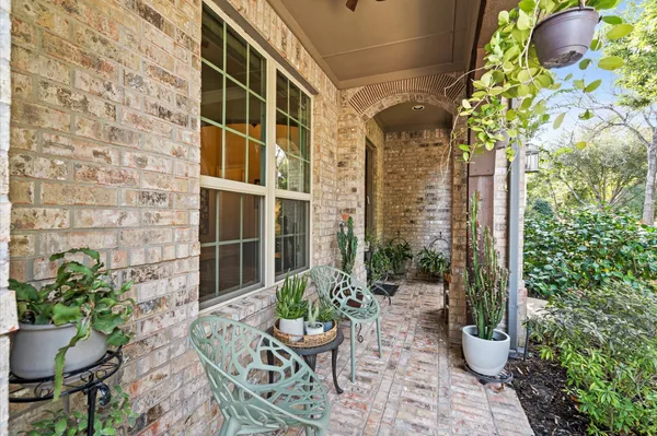 a view of a porch with chairs and potted plants