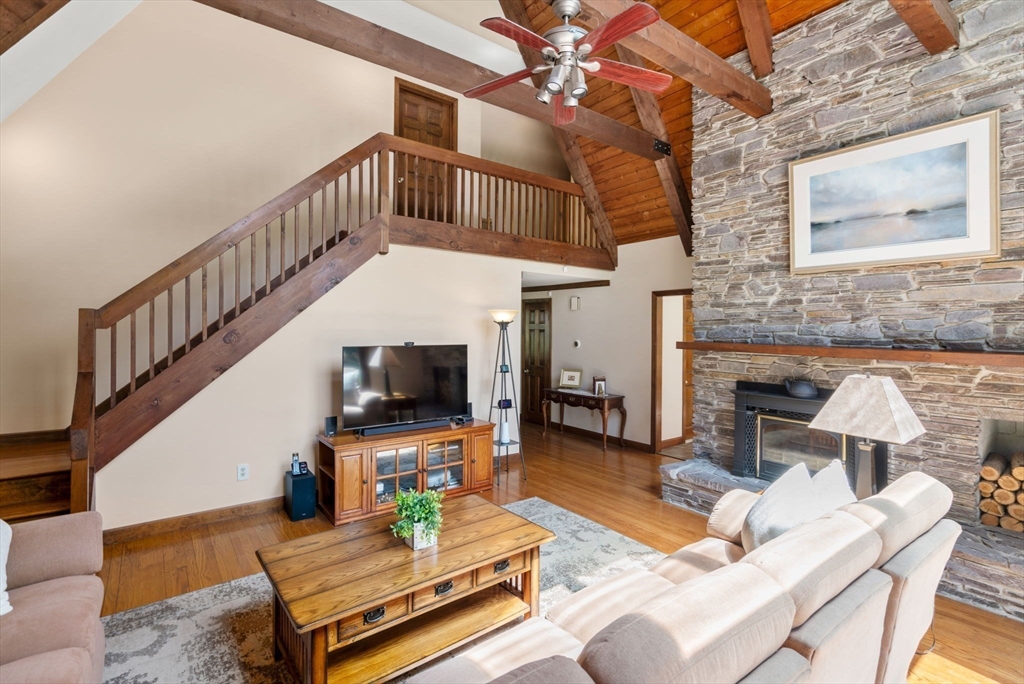 27 Stuart Road Rochester, MA 02770 - Photo 11 of 42 a living room with furniture a fireplace and a flat screen tv