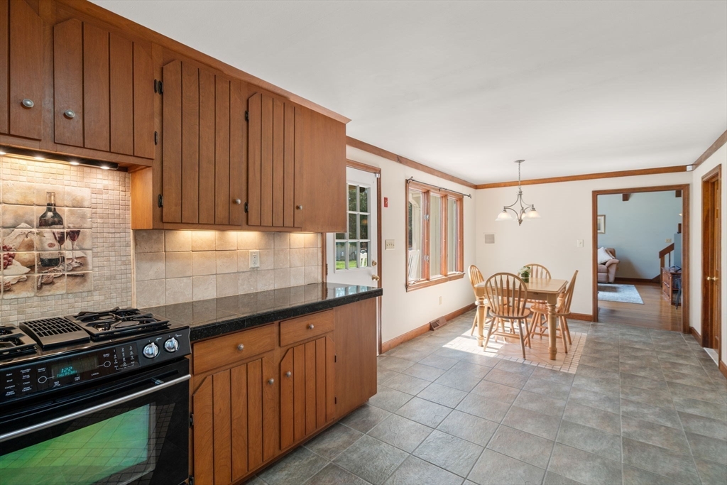 27 Stuart Road Rochester, MA 02770 - Photo 17 of 42 a kitchen with granite countertop wooden cabinets and a stove top oven