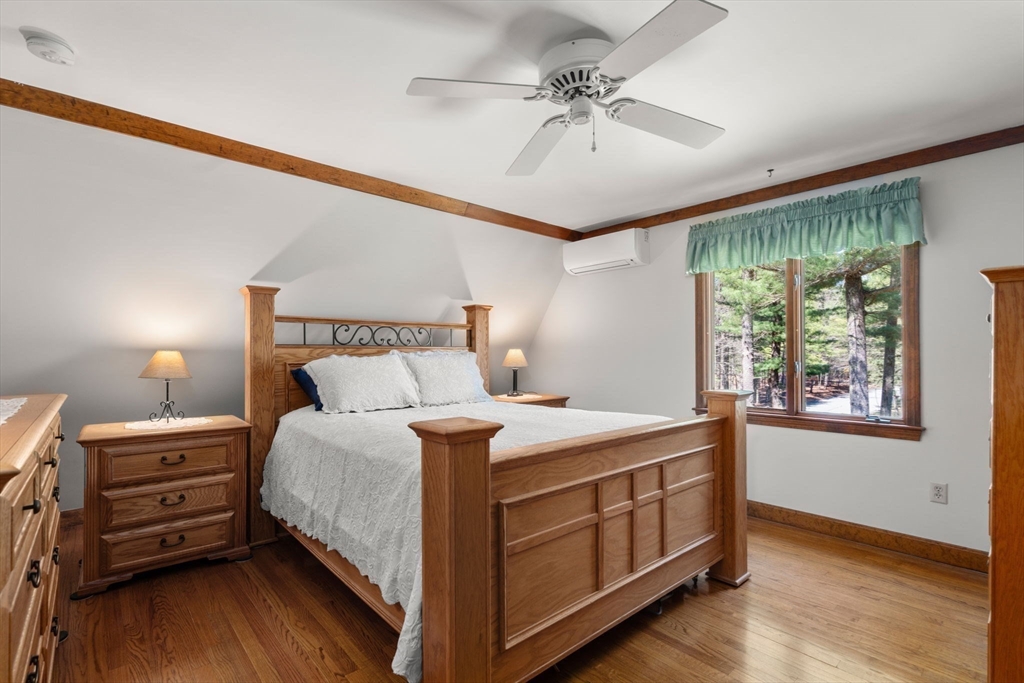27 Stuart Road Rochester, MA 02770 - Photo 18 of 42 a bedroom with a bed a chandelier and a dresser