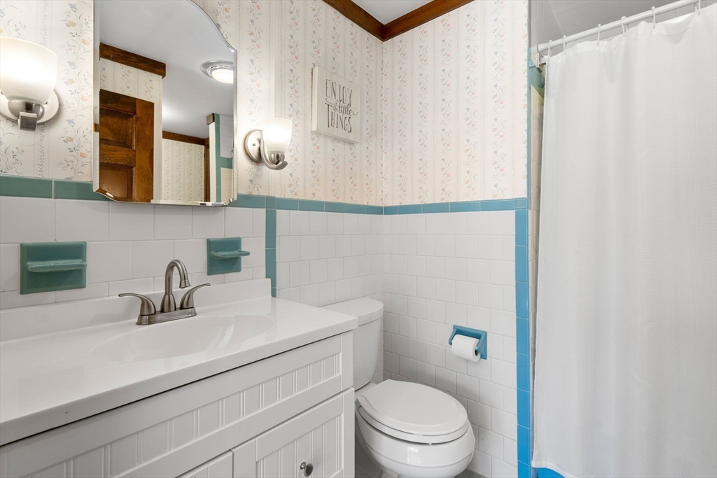 27 Stuart Road Rochester, MA 02770 - Photo 34 of 42 a bathroom with a sink a toilet a mirror and shower curtain