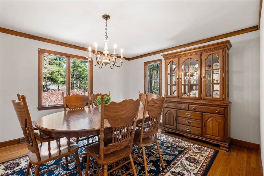 27 Stuart Road Rochester, MA 02770 - Photo 39 of 42 a dining room with furniture a chandelier and wooden floor