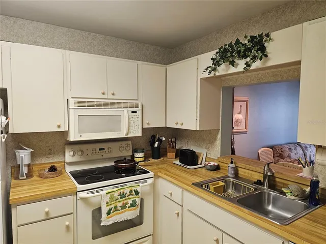 a kitchen with a sink stove top oven and microwave