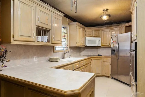 a kitchen with stainless steel appliances sinks a refrigerator and cabinets