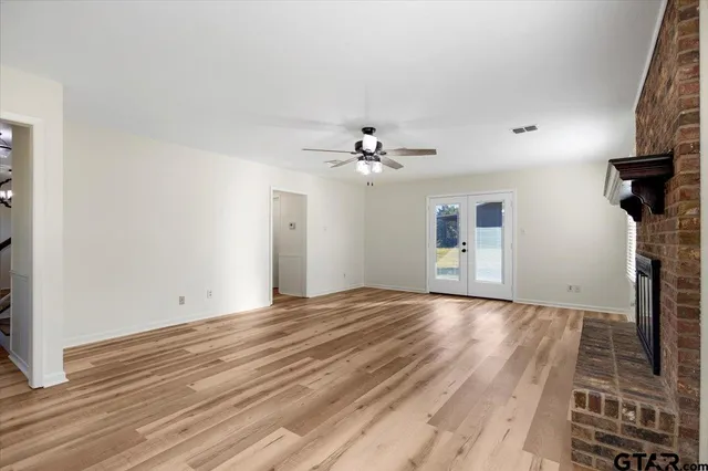 a view of a livingroom with wooden floor and a ceiling fan