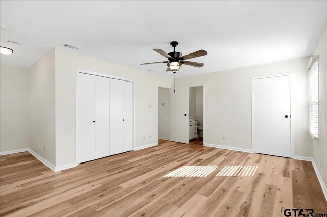 a bathroom with a granite countertop sink mirror vanity and toilet
