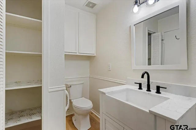 a view of an empty room with wooden floor and a ceiling fan
