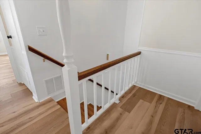 a view of a room with wooden floor and ceiling fan