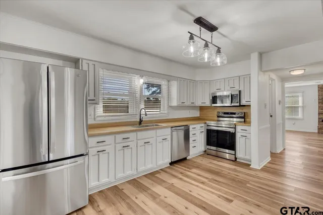 a view of a room with wooden floor and a ceiling fan