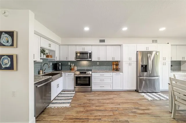 a kitchen with stainless steel appliances cabinets a sink and a stove