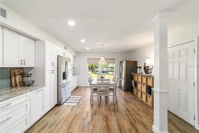 a kitchen with stainless steel appliances a refrigerator a stove a sink and a wooden floor