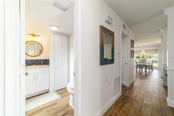 a hallway with wooden floor closet and front door