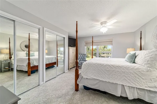 a spacious bedroom with a bed and a chandelier