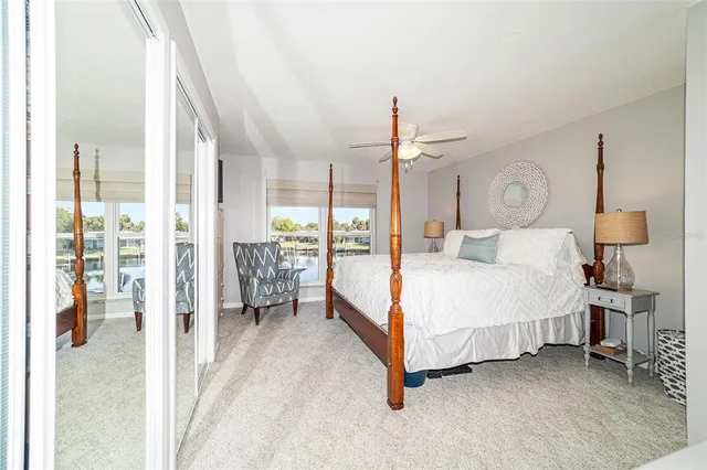 a bedroom with a bed lamp and a large window with outer view