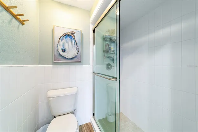 a white toilet sitting next to a shower