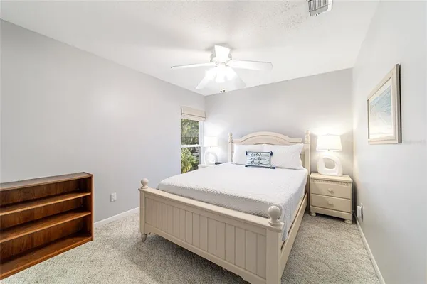 a bedroom with a bed and a ceiling fan
