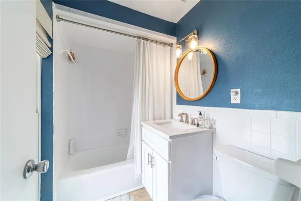 a bathroom with a sink vanity mirror and a bathtub