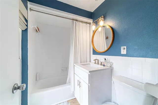 a bathroom with a sink vanity mirror and a bathtub