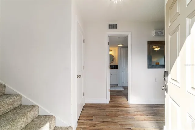 a view of a hallway with wooden floor and a living room