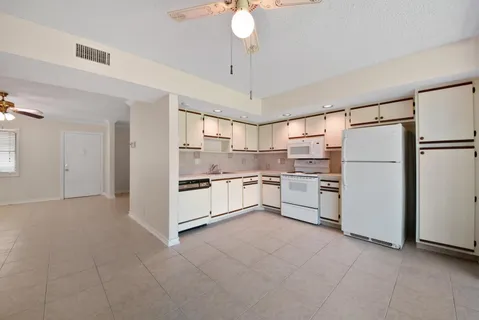 a kitchen with white cabinets and white appliances