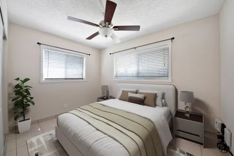 a bedroom with a large bed and potted plant