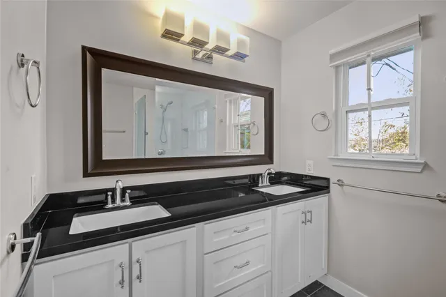 an empty room with ceiling fan and window